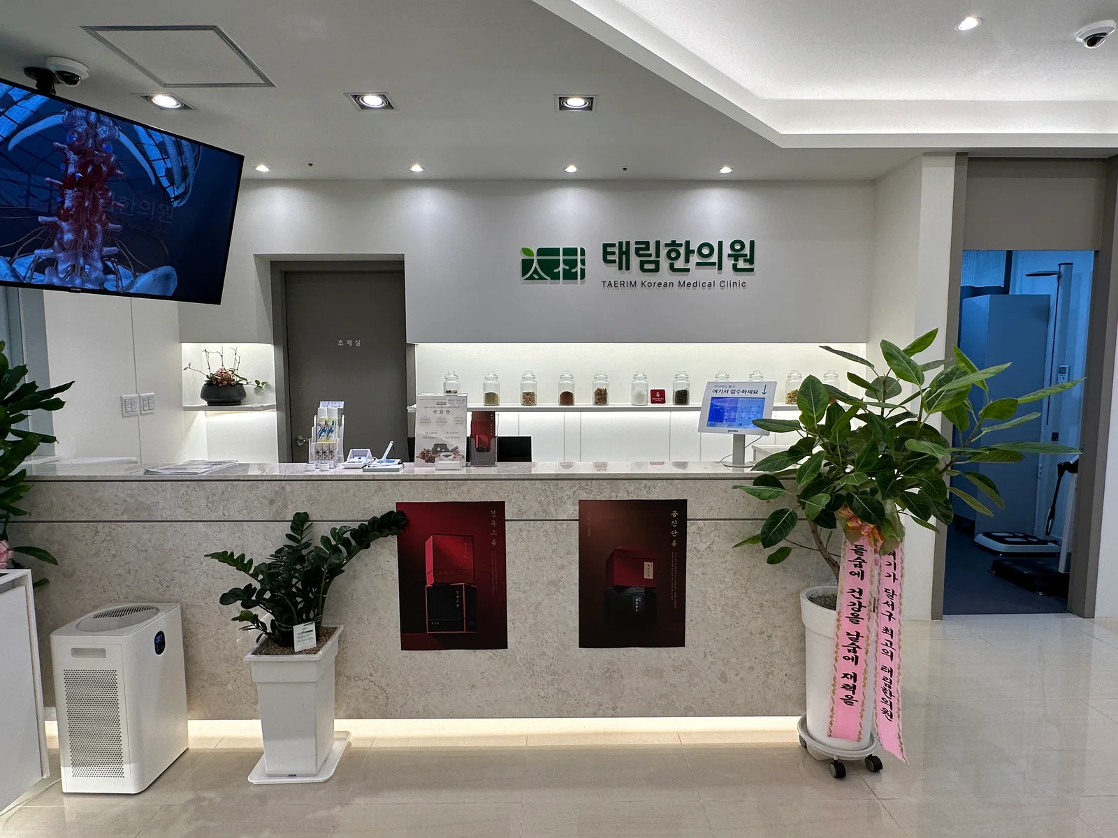 태림한의원 메인 홀 - 접수 데스크와 太林 로고, 약재 진열장
